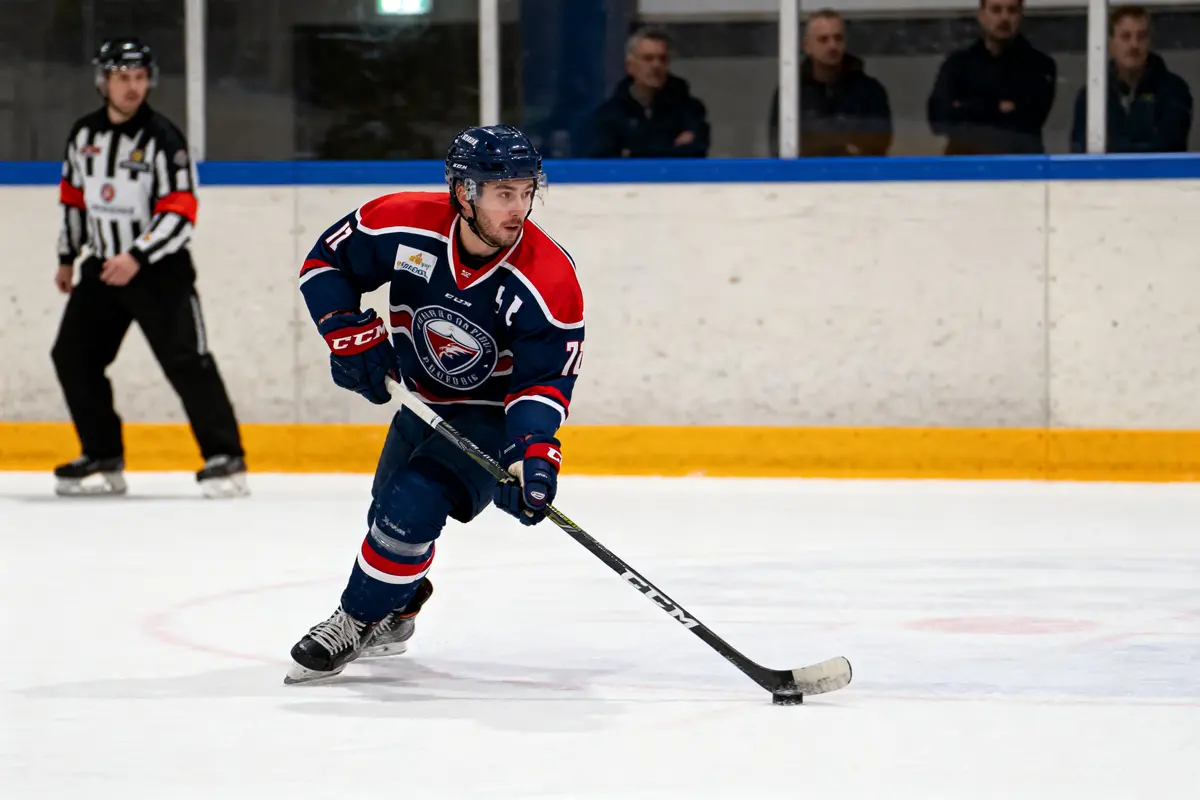 Hockeyeur en action sur la glace, patinant, avec un arbitre et des spectateurs en arrière-plan.
