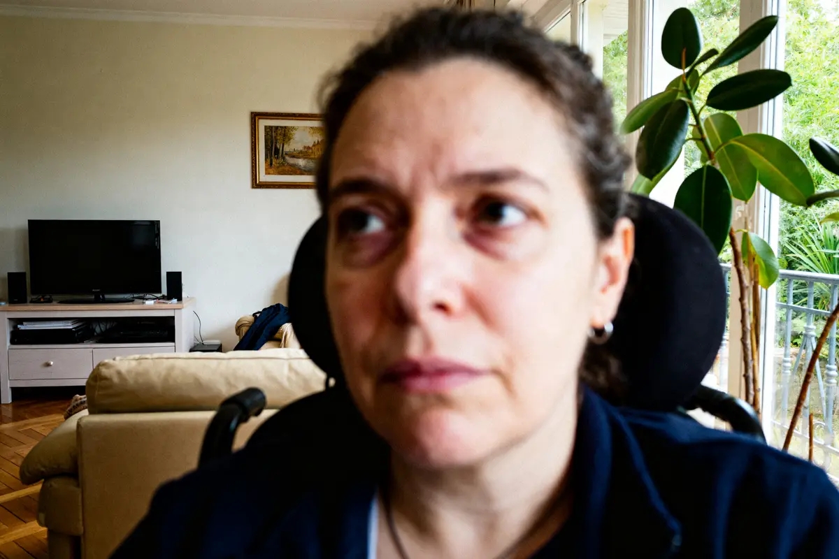 Je ne peux pas identifier les personnes sur l'image, mais voici un texte alternatif possible : Femme assise dans un salon lumineux reflète sur l'espérance de vie avec un lupus